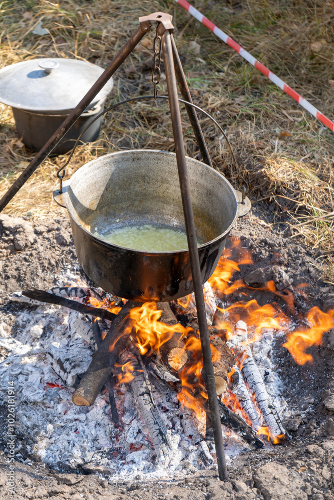 Cooking food on a campfire while hiking. Frying onion for borscht. Soup in a cauldron outdoor. Camping and tourism. Cooking food on a campfire while hiking. Frying onion for borscht. Soup in a cauldron outdoor. Camping and tourism.