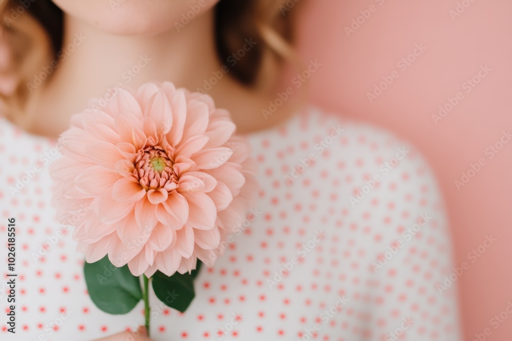 A woman's face partially hidden by a large pink flower, set against a light blue background, emphasizing beauty and floral fashion. A woman's face partially hidden by a large pink flower, set against a light blue background, emphasizing beauty and floral fashion.