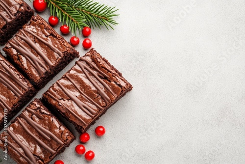 Hands decorating chocolate brownies shaped like Christmas trees with white frosting and red sprinkles, a delicious holiday dessert. photo