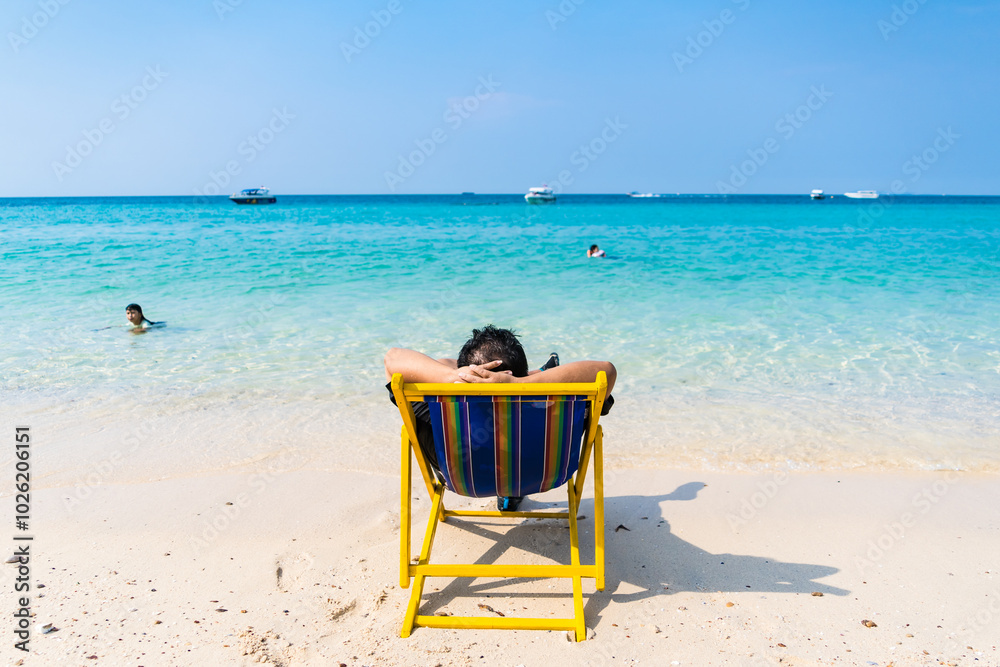 Chonburi, Thailand - February, 04, 2023 : Man Enjoying a Peaceful Day on a Beach Chair at Chonburi, Thailand. Chonburi, Thailand - February, 04, 2023 : Man Enjoying a Peaceful Day on a Beach Chair at Chonburi, Thailand.