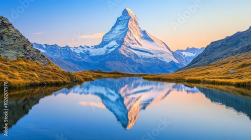 Snow-capped mountains reflected in a crystal-clear lake at sunrise. 