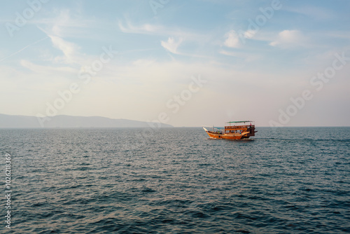 Lonely Boat Sailing on Calm Open Sea at Sunset