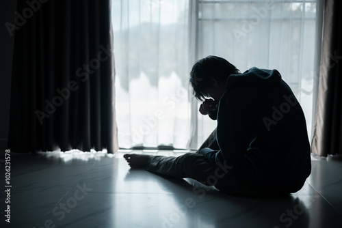 Silhouette of lost cast long shadow, embodying deep despair and hopelessness left him feeling perpetually stressed, sad, and unhappy. man sat alone, feeling weight of anxiety, stress, and depression.