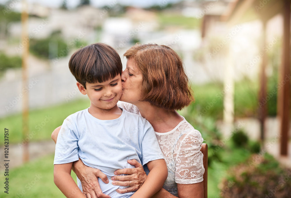 Grandmother, kiss and cheek with grandchild for hug, affection or love on holiday or weekend together in backyard. Grandma, kid and grandson or little boy with smile in joy for comfort or embrace