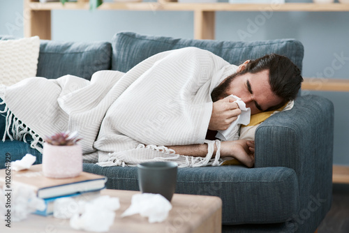 Фотография Man, sick and blowing nose in home, cold and tissue for blocked sinus or influenza