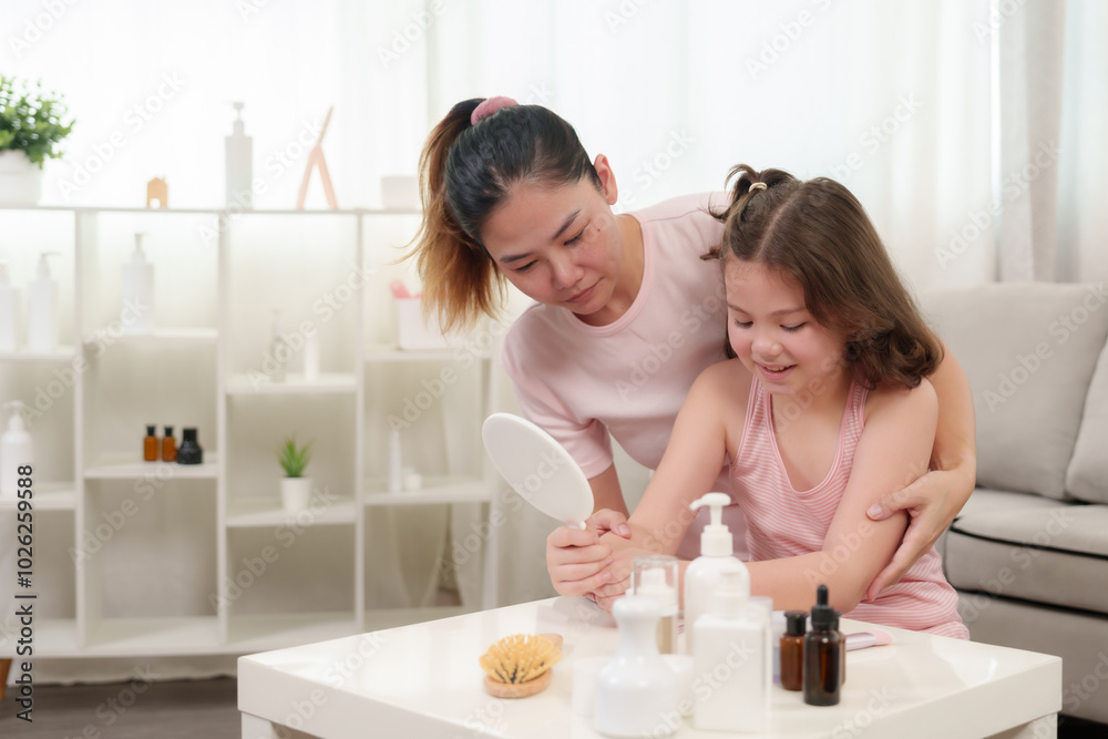 Mother helps young daughter with self-care routine, guiding application of skincare products. Both smiling warmly, bonding moment in modern home interior filled with natural light, enhancing intimacy. Mother helps young daughter with self-care routine, guiding application of skincare products. Both smiling warmly, bonding moment in modern home interior filled with natural light, enhancing intimacy.