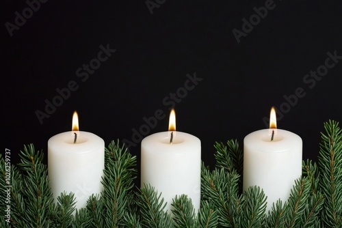 Three lit white candles surrounded by evergreen branches on a black background.