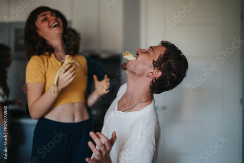 Two friends enjoy a playful moment in the kitchen, laughing and jokingly balancing bananas. The scene conveys joy, friendship, and a lighthearted atmosphere. photo