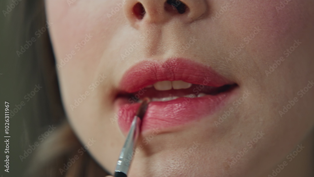 Closeup girl putting lipstick for makeup using special small brush at bathroom Closeup girl putting lipstick for makeup using special small brush at bathroom