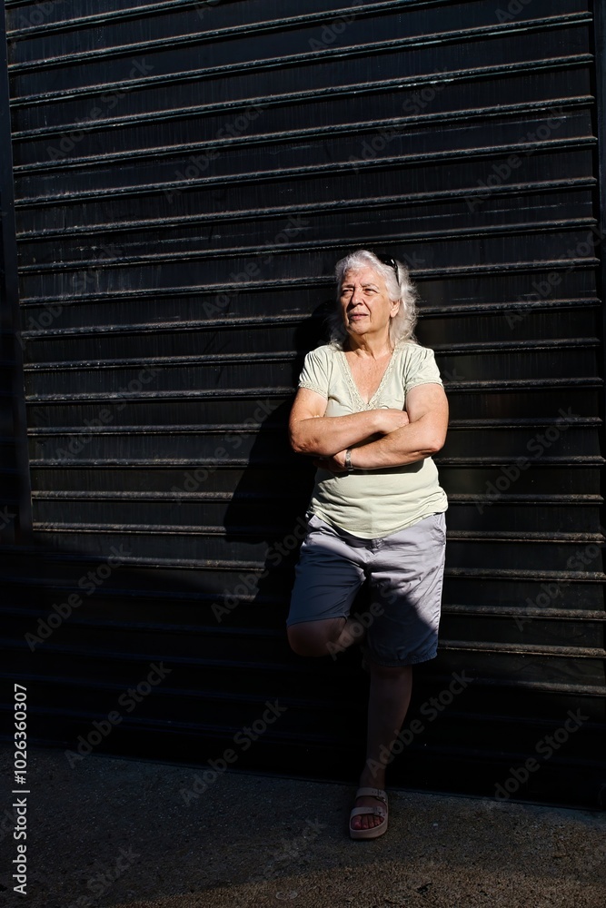 Cheerful gray-haired elderly woman on a dark background, low key. Cheerful gray-haired elderly woman on a dark background, low key.