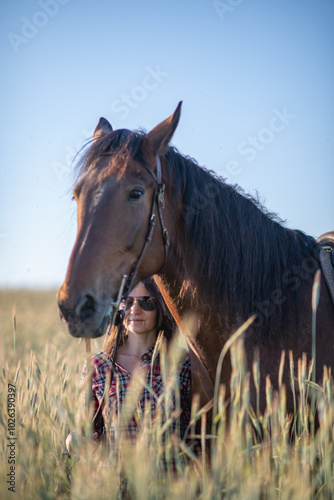Portrait of a young beautiful dark-haired girl with a horse outdoors.