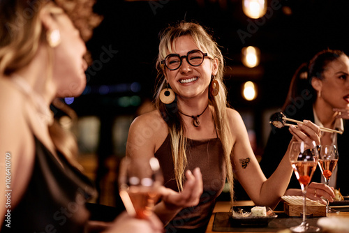 Canvas Print Friends Enjoying Sushi and Wine in a Lively Restaurant Setting
