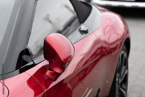 red car side view with rear view mirror, car dealing and manufacturing, cropped car image, selective focus