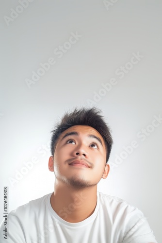 Dreaming Filipino Guy Looking Up Against White Background