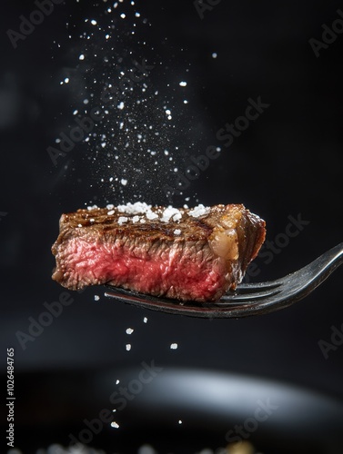 Perfectly seared beefsteak on a fork in a dark atmosphere at a modern restaurant.