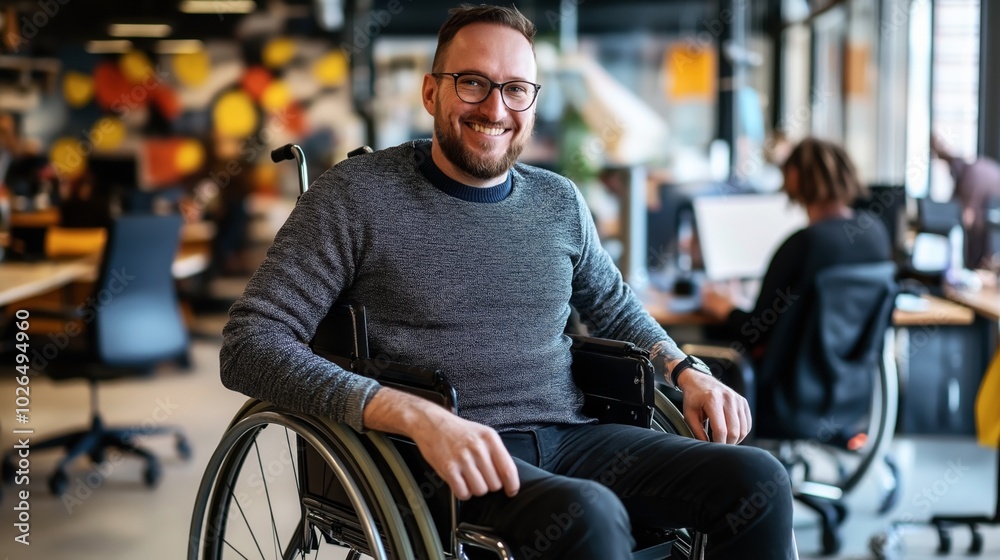 Smiling man in wheelchair working in modern collaborative office space with blurred background featuring colorful decor and colleagues at desks. Smiling man in wheelchair working in modern collaborative office space with blurred background featuring colorful decor and colleagues at desks.