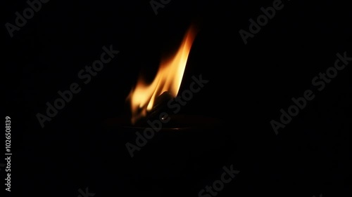 A lighter lighting lantern or torch in the dark background. combustion process.