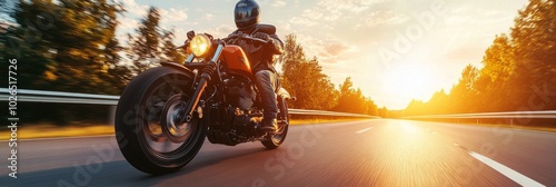 Rider cruising on a motorcycle at sunset along a deserted highway in the coun...