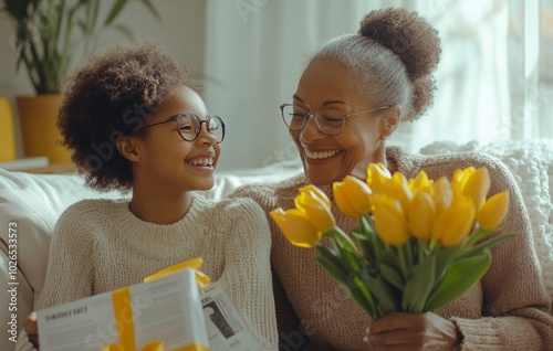 A joyful grandmother and granddaughter celebrate together with flowers and a ...