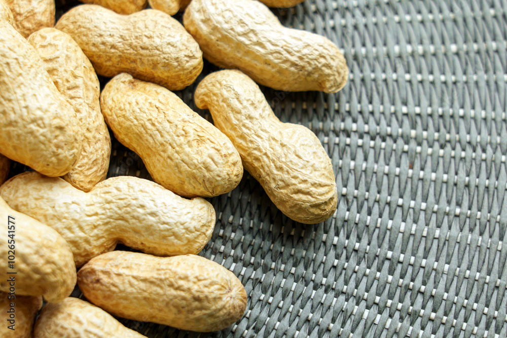Large group of peanuts with textured nutshell on a green rustic braided cloth. Macro Large group of peanuts with textured nutshell on a green rustic braided cloth. Macro