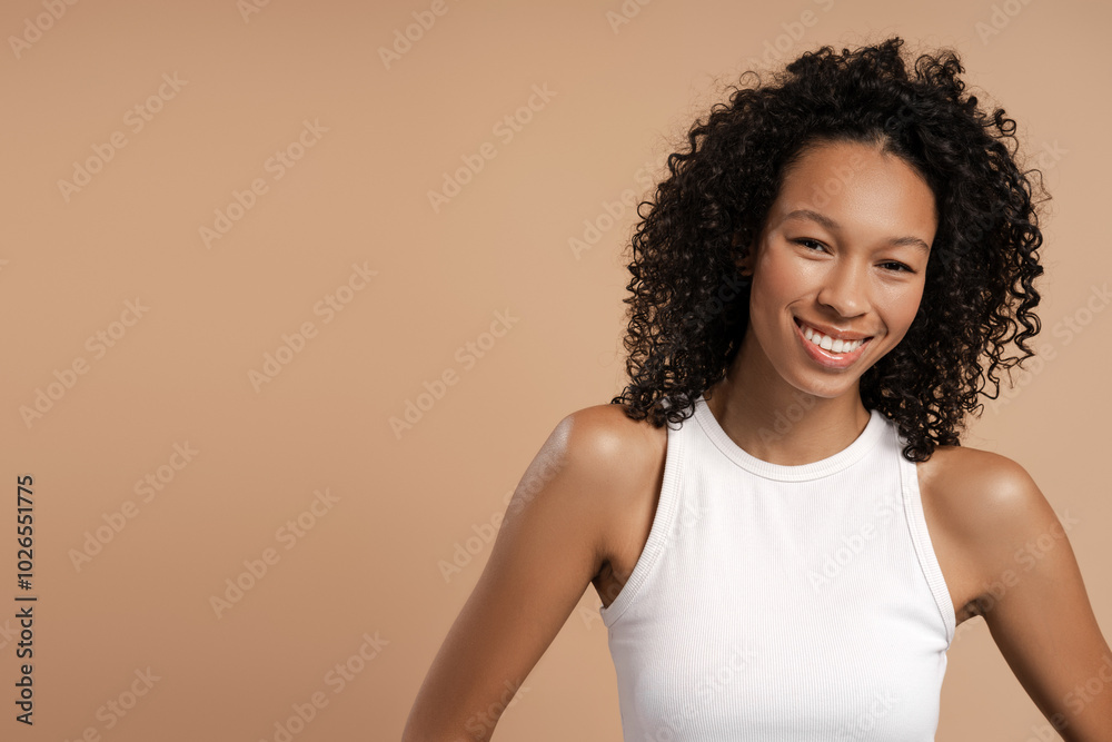 Happy African American woman looking at camera, copy space, against on beige background Happy African American woman looking at camera, copy space, against on beige background