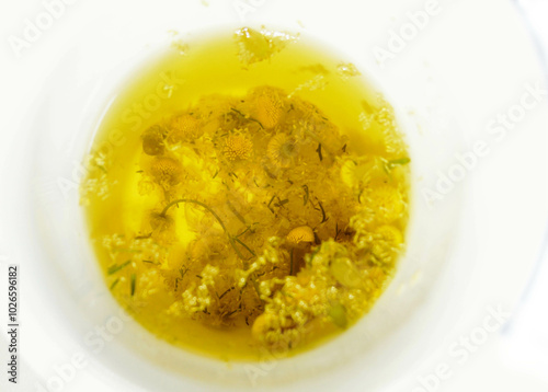 chamomille  tea  on white cup with herbs