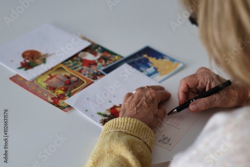 An elderly woman writing Christmas cards