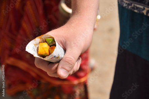 Traditional local delicacy is mango with pepper sold near temples in Hampi, India.