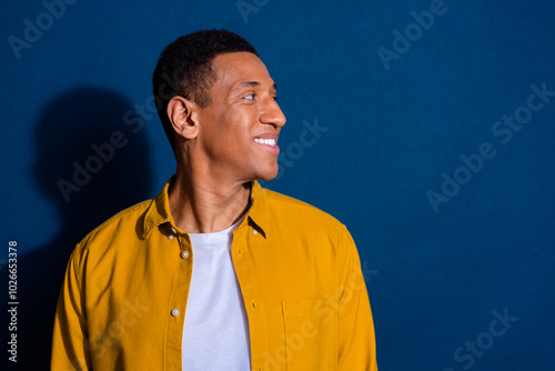 Side profile photo of young student man wearing stylish shirt with new haircut looking novelty smiling isolated on dark blue color background