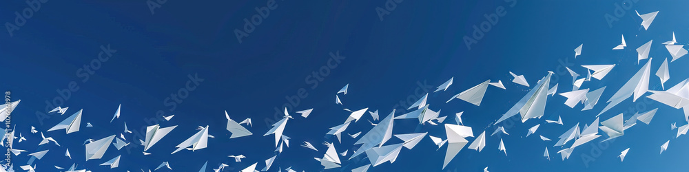 Against a deep blue sky, a flurry of white paper airplanes soar and then gently descend. Against a deep blue sky, a flurry of white paper airplanes soar and then gently descend.