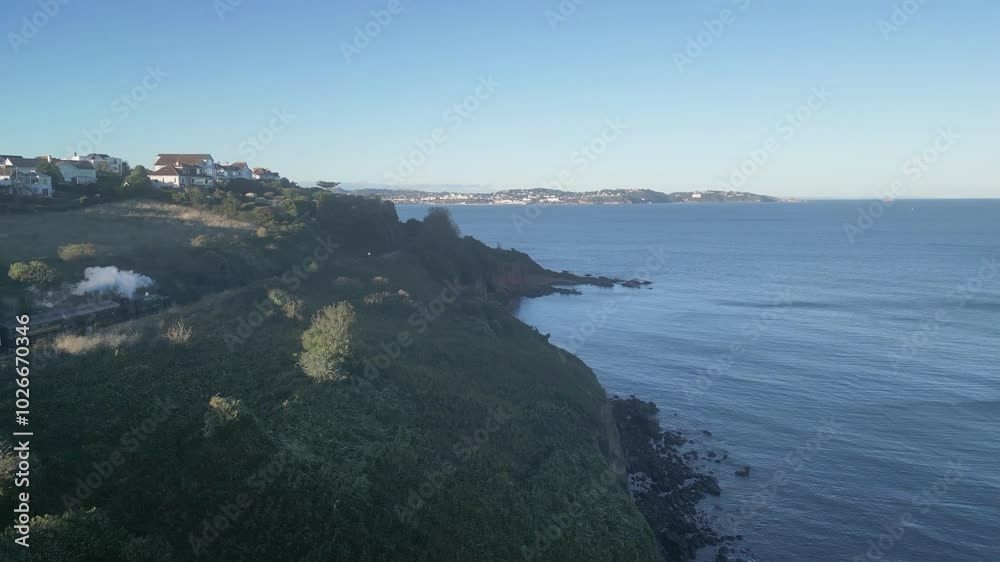 Torbay, South Devon, England: DRONE VIEWS: The drone tracks a steam train heading from Kingswear to Paignton. Torbay is a popular UK holiday destination with many tourist attractions (Clip 1). Torbay, South Devon, England: DRONE VIEWS: The drone tracks a steam train heading from Kingswear to Paignton. Torbay is a popular UK holiday destination with many tourist attractions (Clip 1).