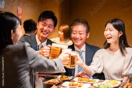 Foto 居酒屋で乾杯をする男女のビジネスパーソン