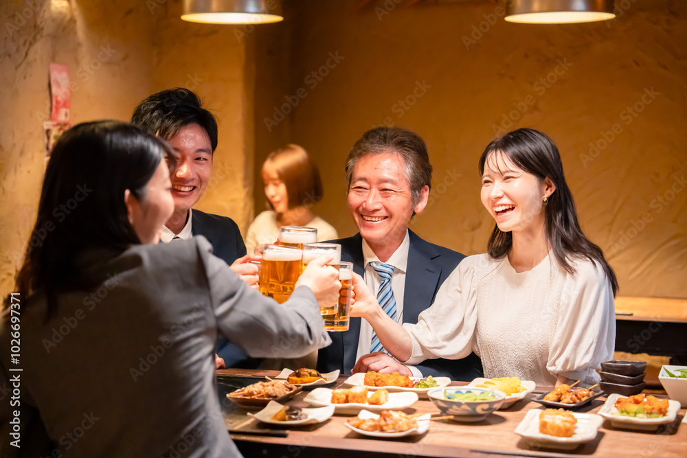 居酒屋で乾杯をする男女のビジネスパーソン 居酒屋で乾杯をする男女のビジネスパーソン