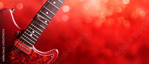  A red electric guitar sits against a red and white backdrop, with a softly blurred arrangement of lights behind, creating a bokeh effect