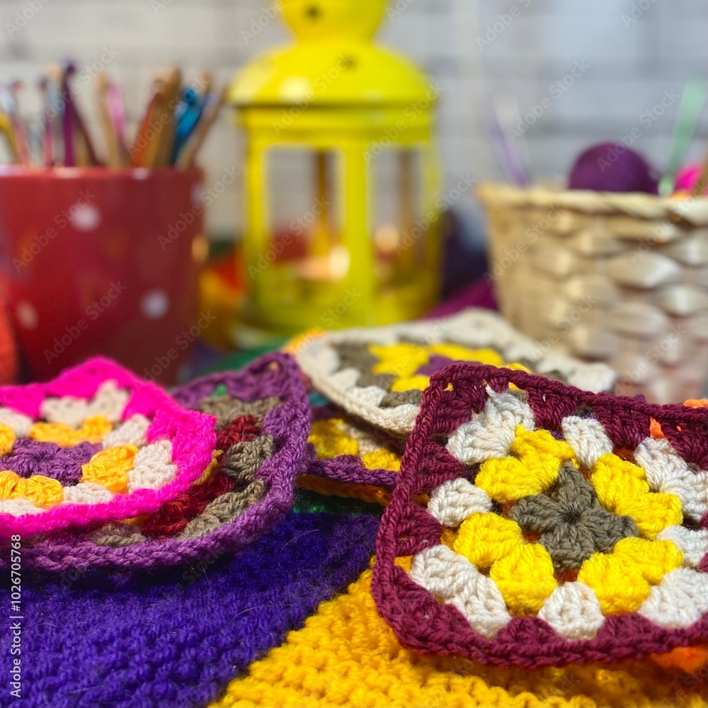Crochet granny square motives set on the table, clews and hooks and basket cozy home photo Crochet granny square motives set on the table, clews and hooks and basket cozy home photo