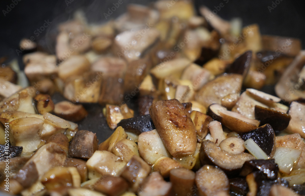 Detail of a hot mushroom pan on the stove, porcini mushrooms and chanterelles Detail of a hot mushroom pan on the stove, porcini mushrooms and chanterelles