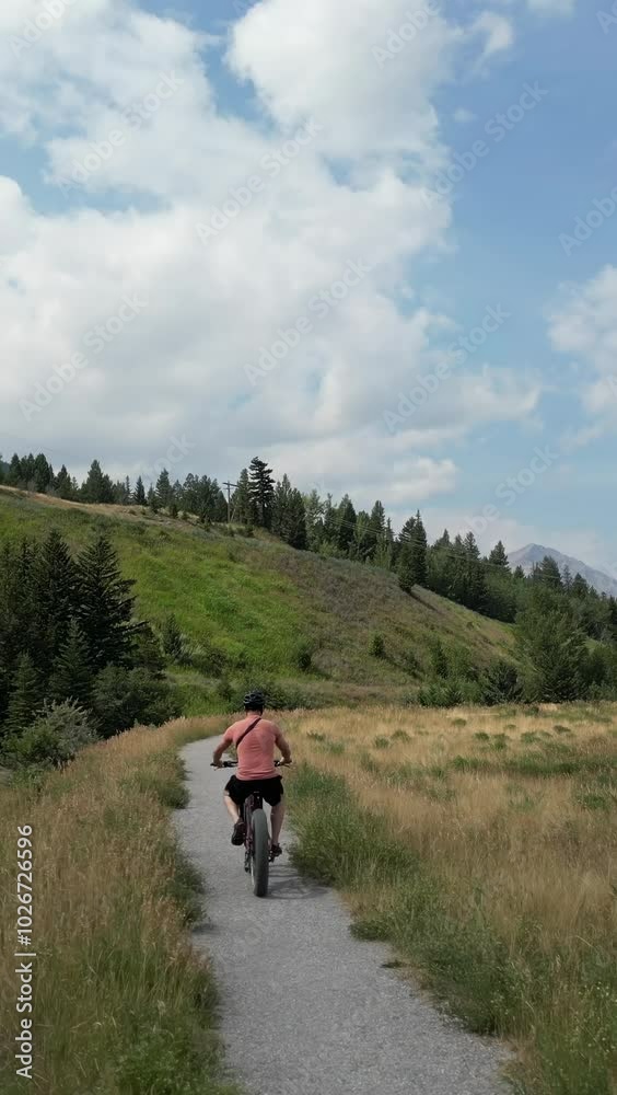 A man riding an ebike enjoys a beautiful day in nature. This video evokes themes of adventure, sustainability, and healthy living. Crowsnest Pass, Alberta, Canada. A man riding an ebike enjoys a beautiful day in nature. This video evokes themes of adventure, sustainability, and healthy living. Crowsnest Pass, Alberta, Canada.