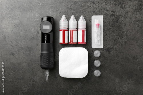 Permanent makeup equipment kit on grey table, flat lay photo