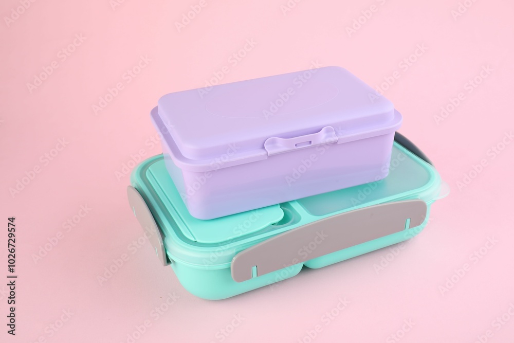 Two plastic lunch boxes on light pink background Two plastic lunch boxes on light pink background