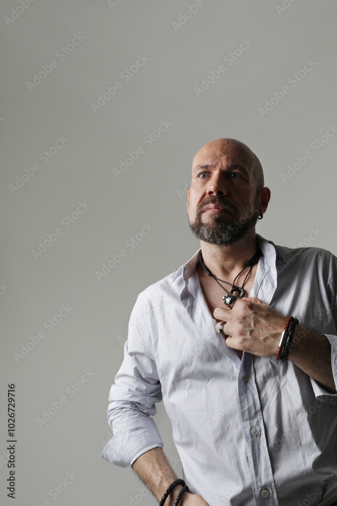 Portrait of bearded man with shaved head looking away and poses at the studio. Vertical. Portrait of bearded man with shaved head looking away and poses at the studio. Vertical.