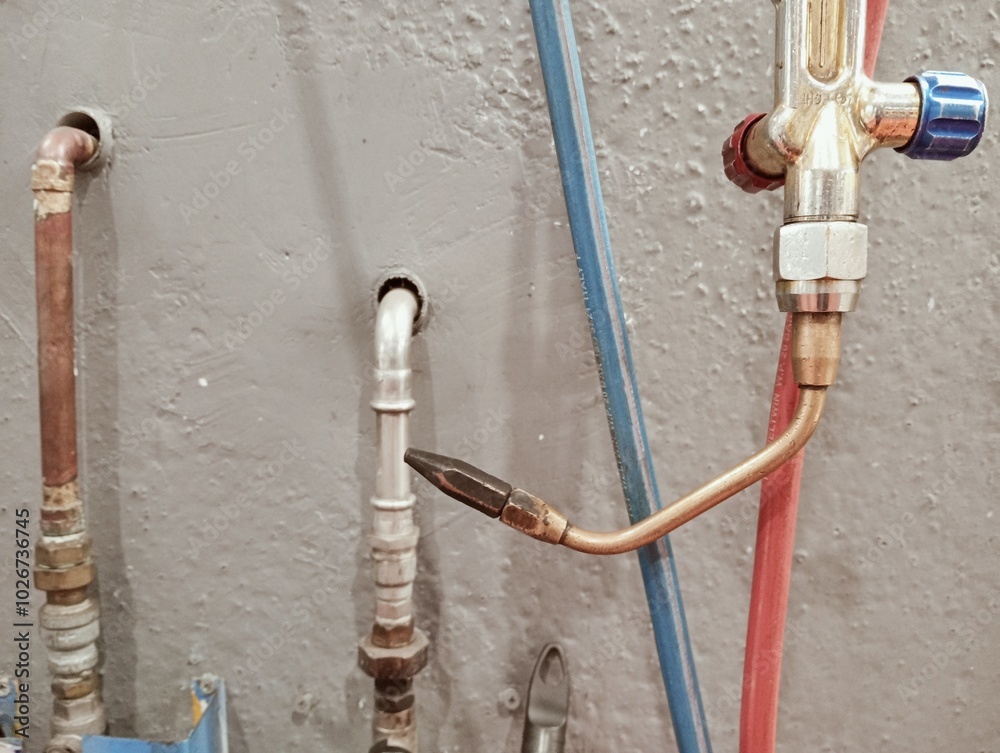 welding torch with pipes and pressure reducers on a workshop wall. Industrial equipment