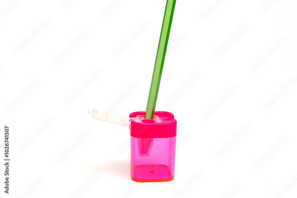 A pink container with a green pencil sticking out of it. The pencil is green and has a green handle
