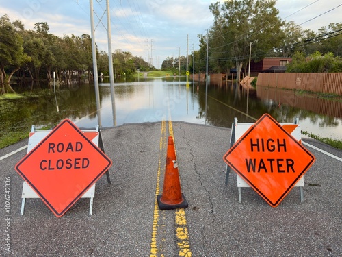 Road Closed. Stop road sign. High Water sign. Florida tropical storm. Hurricane flood road blocked off. School road damaged. Danger for car and pedestrian. Power line rain tropical climate destruction photo