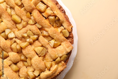 Tasty homemade apple pie on beige background, top view. Space for text