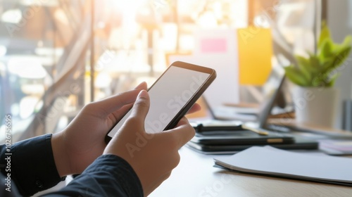 Small business owner checking a smartphone, clean and minimalistic image with blurred workspace and copy space.