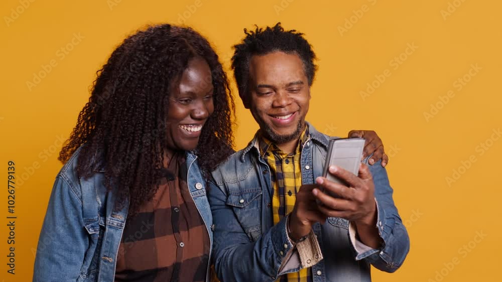 African american young couple having fun together with photos on smartphone, enjoying sweet moments with each other. Cute husband and wife take pictures on mobile phone. Camera A. African american young couple having fun together with photos on smartphone, enjoying sweet moments with each other. Cute husband and wife take pictures on mobile phone. Camera A.
