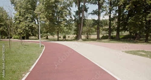 Wallpaper Mural A young fit couple goes for a jog together on a sunny day in the park. They are running on a red running track. Shot with a slow-motion camera. Torontodigital.ca