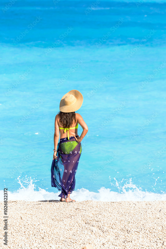 Woman with straw hat on famous Myrtos beach. Kefalonia, Greek Islands, Greece Woman with straw hat on famous Myrtos beach. Kefalonia, Greek Islands, Greece
