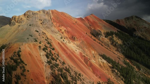 Aerial back away from Red Mountain near Ouray on Million dollar highway at sunset