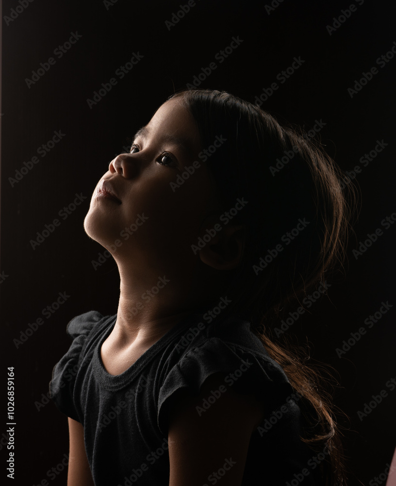 A captivating portrait of a young girl gazing thoughtfully upwards, deep in contemplation A captivating portrait of a young girl gazing thoughtfully upwards, deep in contemplation